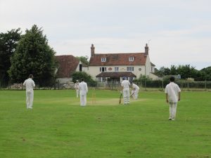 cricketers in front of a village pub